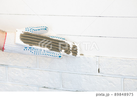 Professional Builder gluing decorative tile on wall. worker mounts decorative brick on wall Professional Builder gluing decorative tile on wall. worker mounts decorative brick on wall 89848975