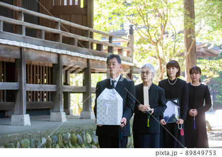 納骨式を行う遺骨を持った遺族（4人） 89849753