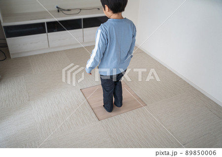 タイルカーペットが汚れたので、男の子が一枚だけ交換する図 89850006