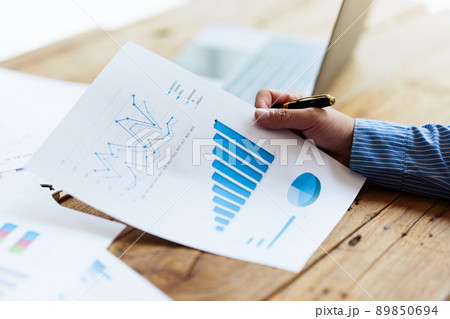 Asian Businessman working to analyze technical price graph and indicator with business team talking by cell phone. account or saving money or insurance concept. 89850694