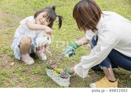 女性と子供が一緒に花の手入れや水やりをしている 女性と子供が一緒に花の手入れや水やりをしている 89852002