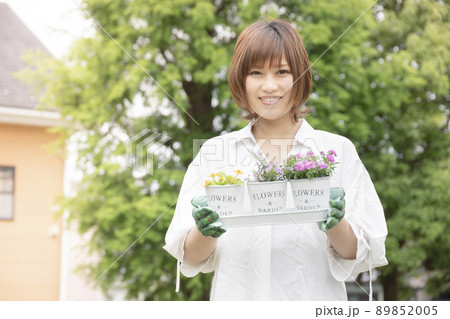 プランターで花を育ててガーデニングを楽しむ笑顔の女性 プランターで花を育ててガーデニングを楽しむ笑顔の女性 89852005