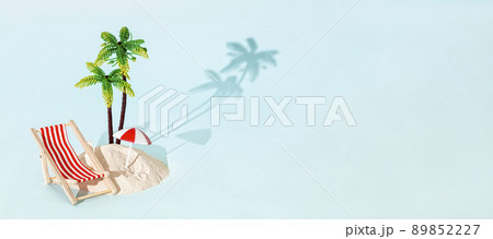Toy beach deck chair and palm tree with sand on bleu background. Creative summer beach concept. 89852227