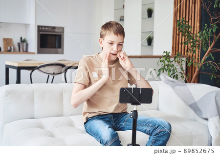 Teenage boy learns to play the folk musical instrument jew's harp online. Distance music education or hobby 89852675