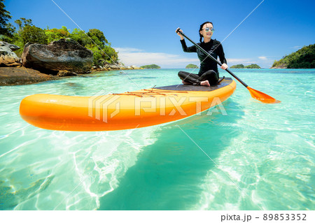 Asian woman relax on the beach with SUP BOARD Asian woman relax on the beach with SUP BOARD 89853352