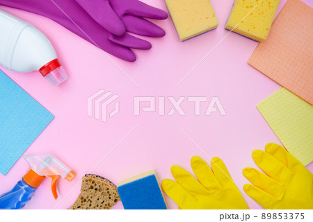 Tools and accessories for cleaning home, kitchen and office. Cleaning business. Place for text and label. Copy space. Pink background. Rubber gloves, sponge and detergent. Cleanliness concept. 89853375