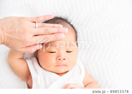 赤ちゃんのおでこに手を当てる　発熱やうつ熱　体温　確認 89853378