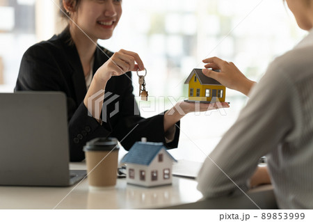 real estate agent holding house key to his client after signing contract agreement in office,concept for real estate, moving home or renting property real estate agent holding house key to his client after signing contract agreement in office,concept for real estate, moving home or renting property 89853999