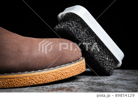 Shoe foam sponge next to a man's brown shoe 89854129