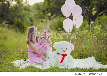 mother and daughter in pink dresses and pink balloons 89854710