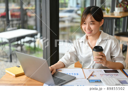 Professional millennial Asian businesswoman working on financial data. remote working Professional millennial Asian businesswoman working on financial data. remote working 89855502