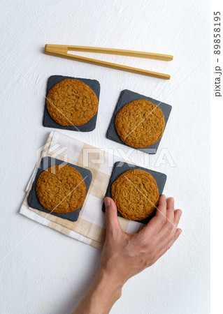 Eat oatmeal cookies. Meat cookies on white background. Flat lay. The concept of vegetarian food. Vertical photo 89858195