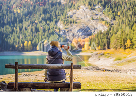 Woman tourist in background of Panoramic morning view of Black Lake Crno Jezero. Calm summer scene of Durmitor Nacionalni Park, Zabljak location, Montenegro, Europe. Beauty of nature concept 89860015