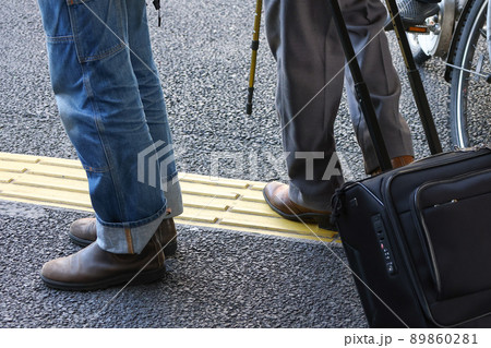 街の点字ブロックと歩行者 89860281