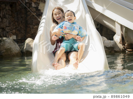 Asian boy and he mother play on the  slider water 89861049