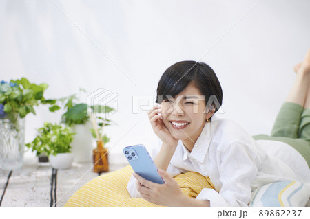 リビングでスマホを見る若い女性 リビングでスマホを見る若い女性 89862237