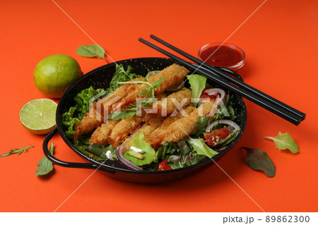 Concept of tasty food with deep-fried shrimp on orange background 89862300