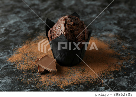 Tasty chocolate muffin on black smokey table Tasty chocolate muffin on black smokey table 89862305