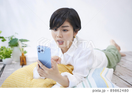 リビングでスマホを見る若い女性 リビングでスマホを見る若い女性 89862480