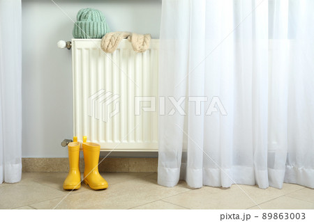 Concept of heating season with radiator and clothes 89863003