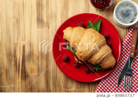 Concept of delicious food with croissant with raspberry jam on wooden background Concept of delicious food with croissant with raspberry jam on wooden background 89863737