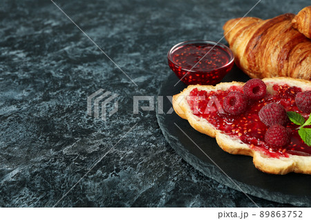 Concept of delicious food with croissants with raspberry jam on black smokey background Concept of delicious food with croissants with raspberry jam on black smokey background 89863752