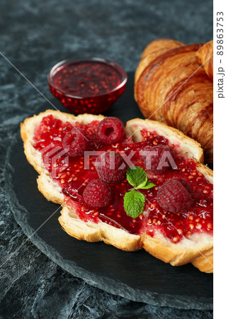 Concept of delicious food with croissants with raspberry jam on black smokey background 89863753
