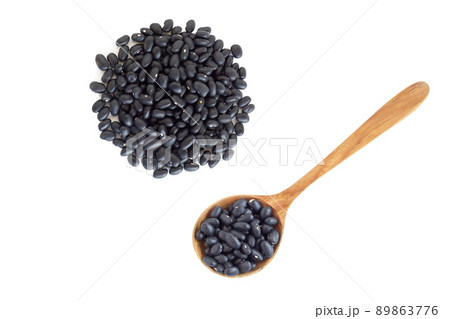 Closeup black beans seeds wooden spoon on white background, healthy food concept 89863776