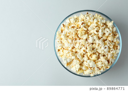 Glass bowl with popcorn on light gray background 89864771