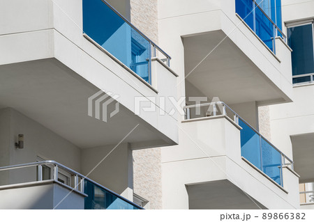 Part of the building. Square balconies with metal railings. 89866382