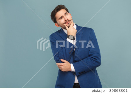 Portrait of puzzled man. Thinking and wondering. Business people concept, richly and success. Indoor, studio shot on light blue background Portrait of puzzled man. Thinking and wondering. Business people concept, richly and success. Indoor, studio shot on light blue background 89868301