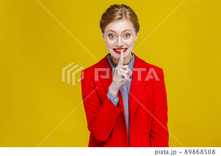 Shh it's secret! Business woman showing secrecy,silence sign . Studio shot, isolated on yellow background Shh it's secret! Business woman showing secrecy,silence sign . Studio shot, isolated on yellow background 89868508