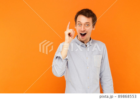 Great idea! Young adult man finger up, have a creative idea. Studio shot, orange background 89868553