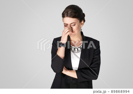 Well dressed woman in suit cry, have problem. Studio shot, indoor. Isolated on grey background Well dressed woman in suit cry, have problem. Studio shot, indoor. Isolated on grey background 89868994