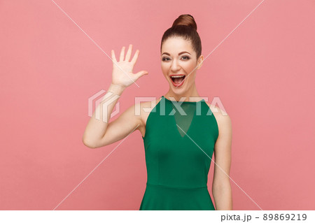 Wel hi! Perfect woman showing hello sign, toothy smiling. Expression emotion and feelings concept. Studio shot, isolated on pink background Wel hi! Perfect woman showing hello sign, toothy smiling. Expression emotion and feelings concept. Studio shot, isolated on pink background 89869219
