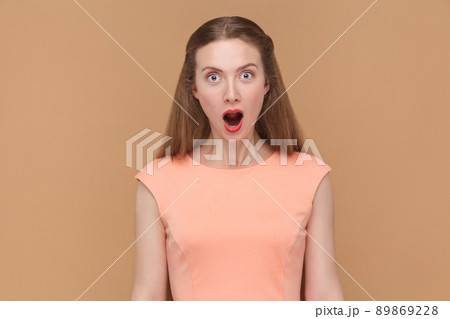 wow, are you serious? amazed woman looking at camera. portrait of emotional, beautiful woman with makeup and long hair in pink dress. indoor, studio shot, isolated on light brown or beige background. wow, are you serious? amazed woman looking at camera. portrait of emotional, beautiful woman with makeup and long hair in pink dress. indoor, studio shot, isolated on light brown or beige background. 89869228