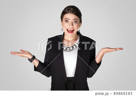 Wow! Businesswoman with big eyes, toothy smile and shocked. Studio shot, indoor. Isolated on grey background 89869285