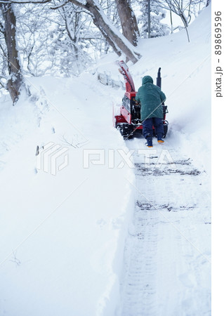 除雪機で雪かきをして道をつくる人 除雪機で雪かきをして道をつくる人 89869596
