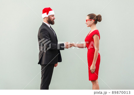 Handshake, celebrate good contract. Well dressed man and lady. Studio shot, gray background 89870013