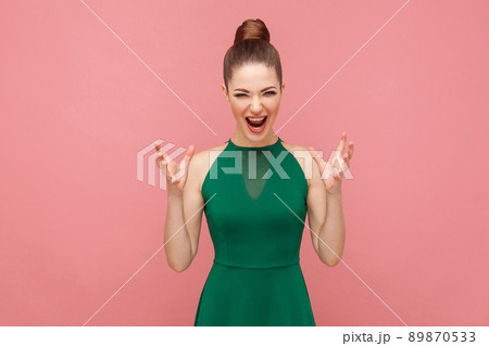 Roar! Angry woman shouting at camera with rage. Expression emotion and feelings concept. Studio shot, isolated on pink background Roar! Angry woman shouting at camera with rage. Expression emotion and feelings concept. Studio shot, isolated on pink background 89870533