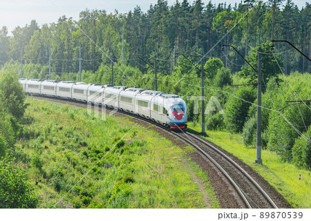 Passenger train moves in the summer forest. 89870539