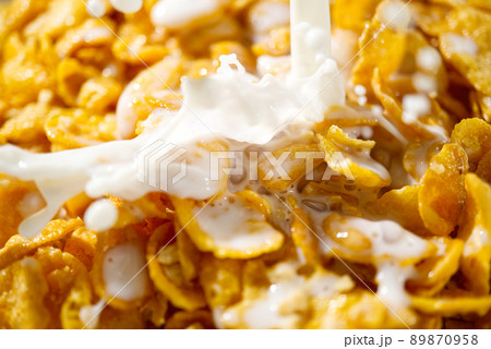 pouring milk into cornflakes close up. soft focus. cornflakes and milk, breakfast concept 89870958
