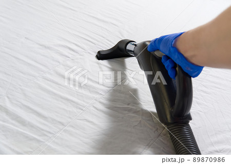Vacuuming bed. Domestic home cleaning concept. Textile sofa chemical cleaning. Upholstered furniture. Early spring cleaning or regular clean up. Cleaning Service conceptatHome, apartments, hotels Vacuuming bed. Domestic home cleaning concept. Textile sofa chemical cleaning. Upholstered furniture. Early spring cleaning or regular clean up. Cleaning Service conceptatHome, apartments, hotels 89870986