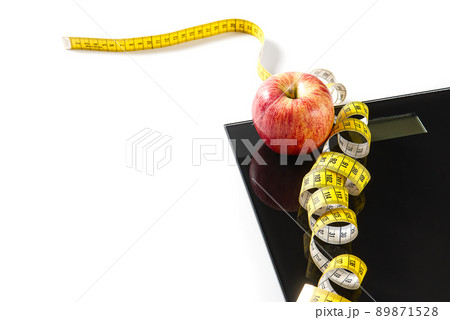 Diet plan, menu or program, tape measure, diet food of fresh fruits on white background, weight loss and detox concept, top view. weight loss concept. Apple and measuring tape. Diet. Diet plan, menu or program, tape measure, diet food of fresh fruits on white background, weight loss and detox concept, top view. weight loss concept. Apple and measuring tape. Diet. 89871528
