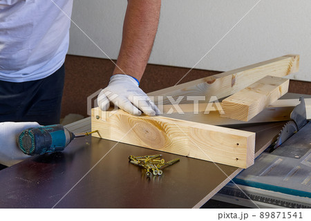 Closeup of professional cabinet makers working with electric circular saw at woodworking workshop. Wood material production. Lumber factory 89871541