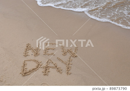 New Day words - drawing on the sand, handwritten on the sea beach sand New Day words - drawing on the sand, handwritten on the sea beach sand 89873790