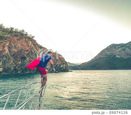 rest on the sea, a walk on a yacht on the waves. a man in a T-shirt and shorts dives into the water, underwater swimming. sunset walk on the water rest on the sea, a walk on a yacht on the waves. a man in a T-shirt and shorts dives into the water, underwater swimming. sunset walk on the water 89874126