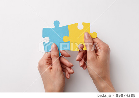 Ukrainian colors puzzle pieces in woman's hands 89874289