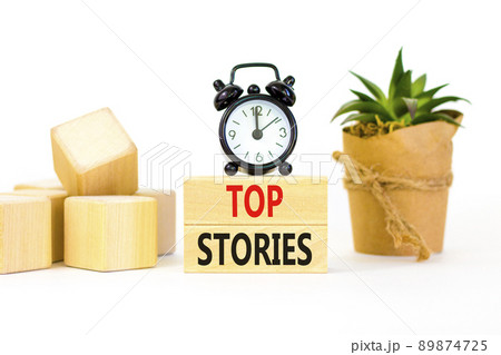 Top stories symbol. Concept words Top stories on wooden blocks on a beautiful white table white background. Black alarm clock. Business story and top stories concept, copy space. Top stories symbol. Concept words Top stories on wooden blocks on a beautiful white table white background. Black alarm clock. Business story and top stories concept, copy space. 89874725