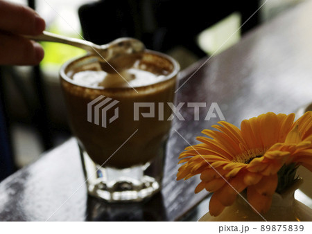 A glass of Latte with a heart painted on the foam on the table in the cafe. Out of focus 89875839